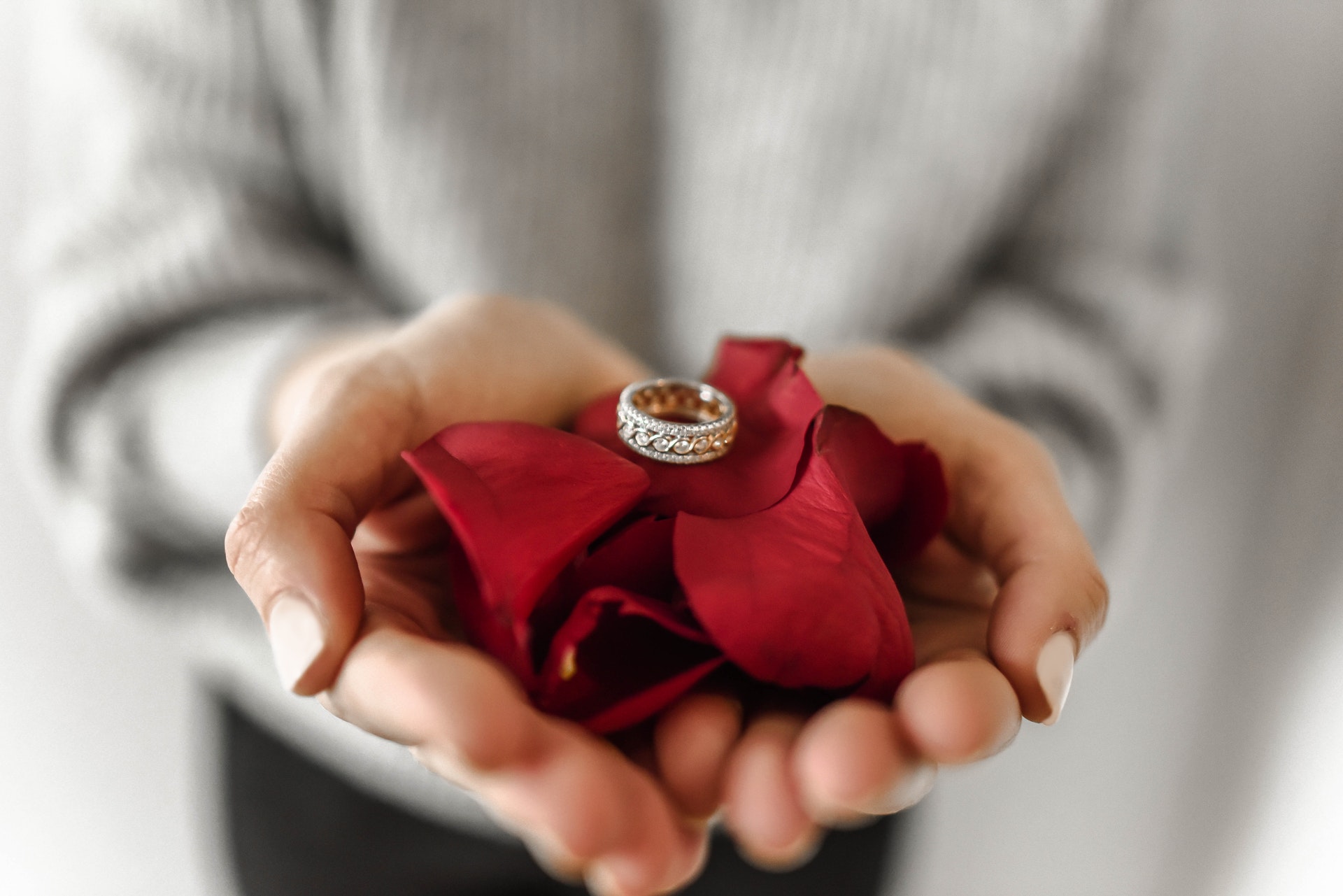 a woman bringing a beautiful rind on rose petals